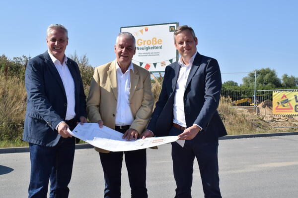 Franchisee Thomas Brand (von links), Sch&ouml;nkirchens B&uuml;rgermeister Gerd Radisch und Christian Dust (Immobilien Mc Donald's) beim Blick auf die Planzeichnung.